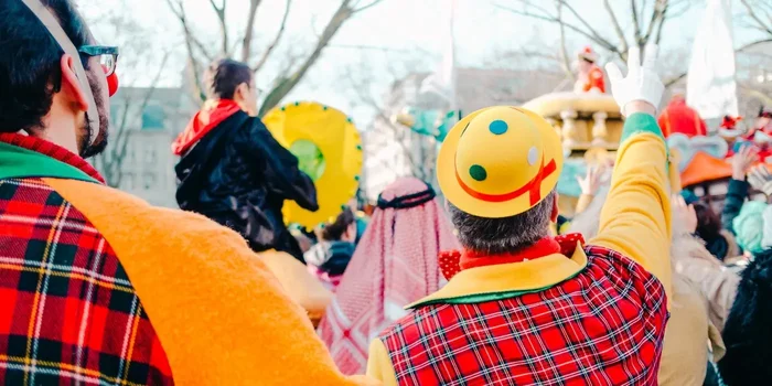 Mehrere verkleidete Personen bejubeln einen Karnevalswagen