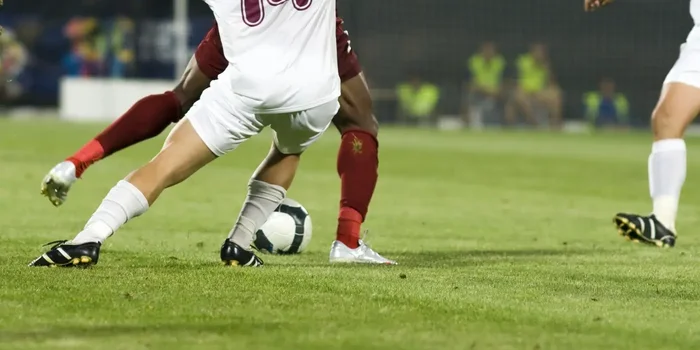 Fußballspieler trägt einen Adidas Fußballschuh und stoppt den Ball