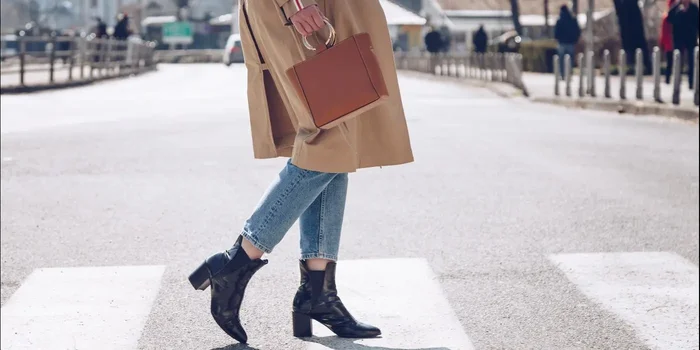 Frau trägt eine braune Handtasche auf einer Straße