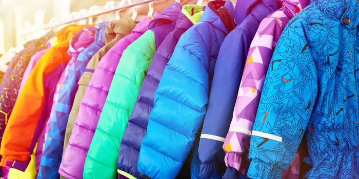 Kinderjacken in verschiedenen Farben hängen auf einer Kleiderstange