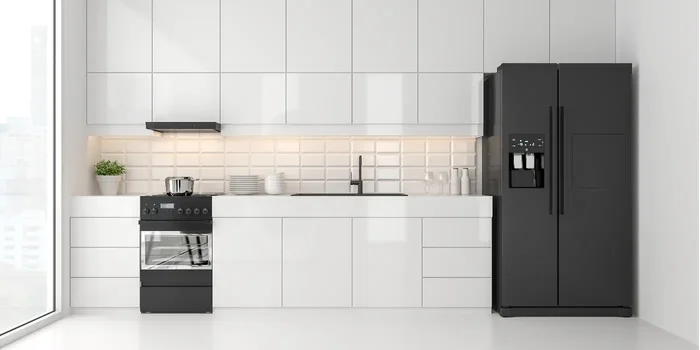 Eine weiße Küche, in der eine schwarze Kühl-Gefrierkombination steht
