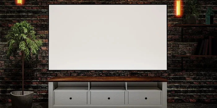 Smart TV mit weißem Bildschirm hängt über einem weißen Lowboard an einer Steinwand