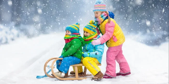 Kinder fahren im Schneegestöber Schlitten