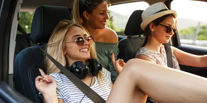 Drei Frauen im Auto hören Musik im Sommer auf Roadtrip
