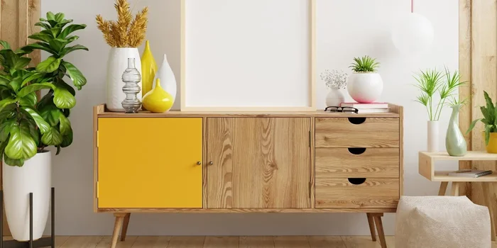 Flacher, halbhoher Schrank aus Holz mit gelber Tür, Schubladen und Dekoelementen