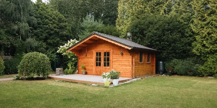 Aufnahme eines Gartenhauses aus hellem Holz, das über eine kleine Terrasse verfügt