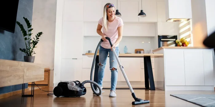 Person saugt den Boden ihrer Wohnung