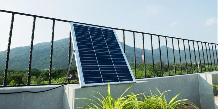 Ein Solarmodul an einem Balkongeländer mit Blick auf Berglandschaft
