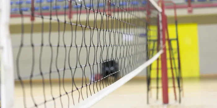 Ein Volleyballnetz mit Schiedsrichterstuhl und Tribünen im Hintergrund