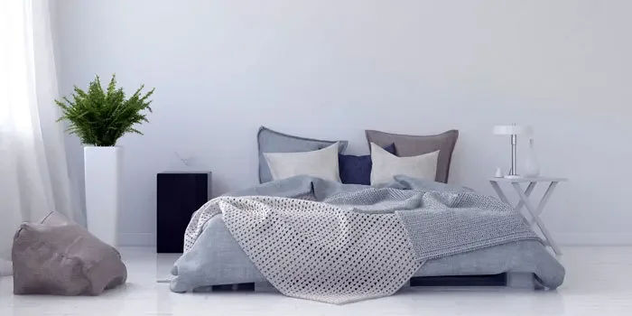 Modernes Bett in puristisch-stilvoll eingerichtetem Zimmer