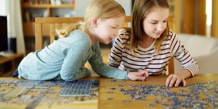 Zwei Mädchen puzzeln an einem Tisch