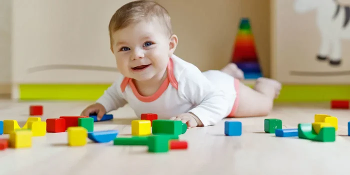 Ein Kleinkind spielt mit Bauklötzen auf dem Boden