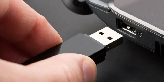 Ein USB Stick wird in den Anschluss am Computer eingesteckt