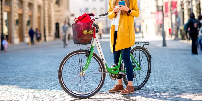 Eine junge Frau steht mit ihrem Fahrrad auf einem Marktplatz