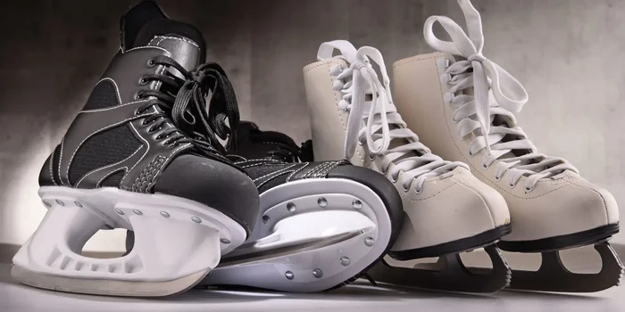 Ein Paar Eishockey Schlittschuhe und ein Paar Eiskunstlauf Schlittschuhe nebeneinander