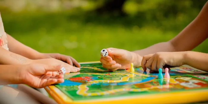 Eine Familie spielt Draußen ein Gesellschaftsspiel