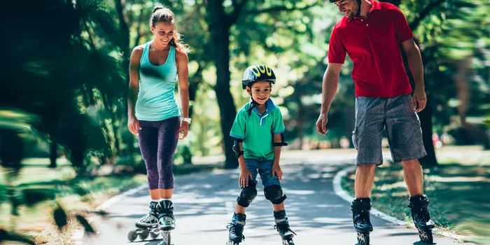 Bild einer Familie, welche im Park Inline Skates fährt