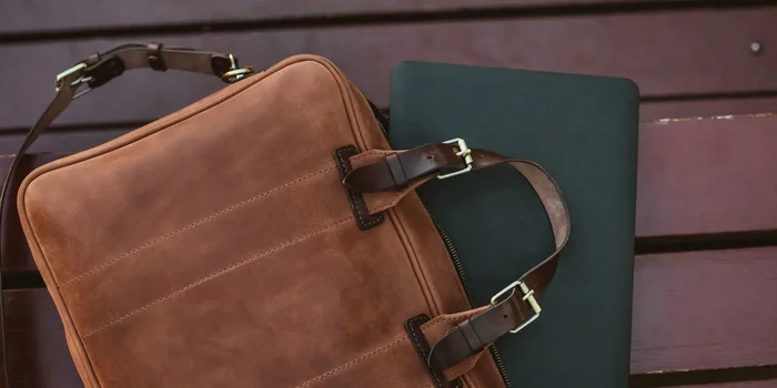 Notebook guckt halb aus einer Laptoptasche aus Leder heraus
