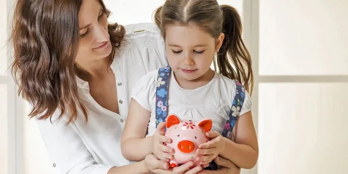 Mutter schenkt ihrer Tochter ein Sparschwein