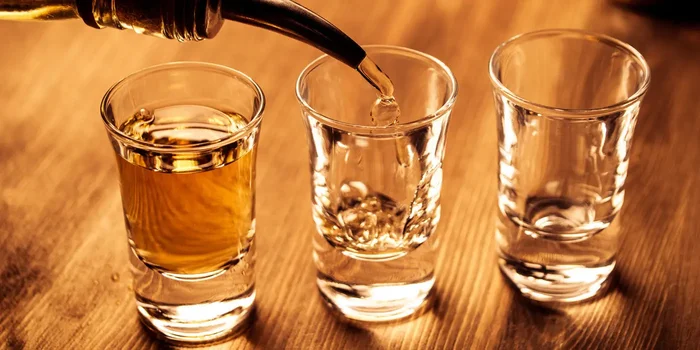 Drei Tequila-Gläser werden mit Tequila eingegossen