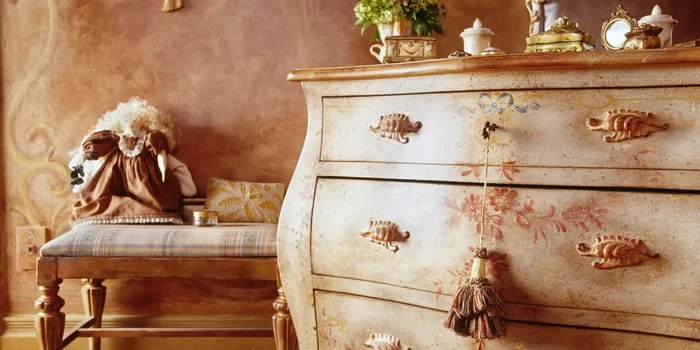 Alte gewölbte Holz-Kommode mit Verzierungen, die passend zu der Schlafzimmer-Dekoration ist
