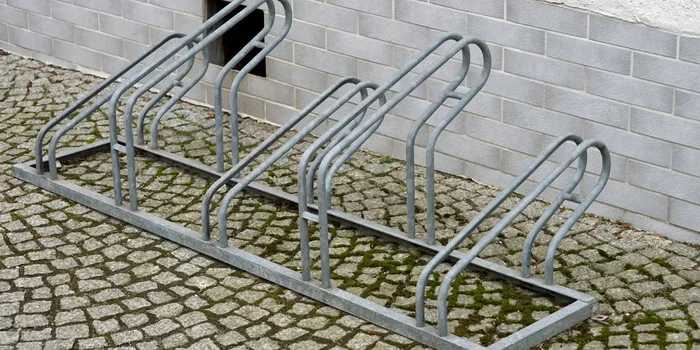 Ein Fahrradständer aus Metall für mehrere Fahrräder steht vor einer Hauswand