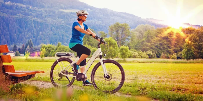 Eine Frau fährt mit ihrem Elektro Fahrrad durch die Natur
