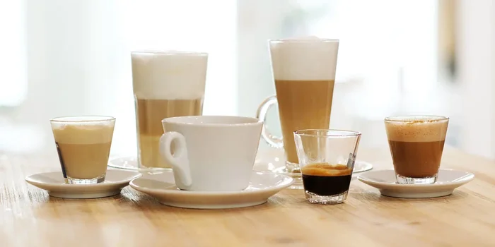 Fünf Gläser unterschiedlicher Größe und eine Tasse sind mit verschiedenen Kaffeegetränken gefüllt