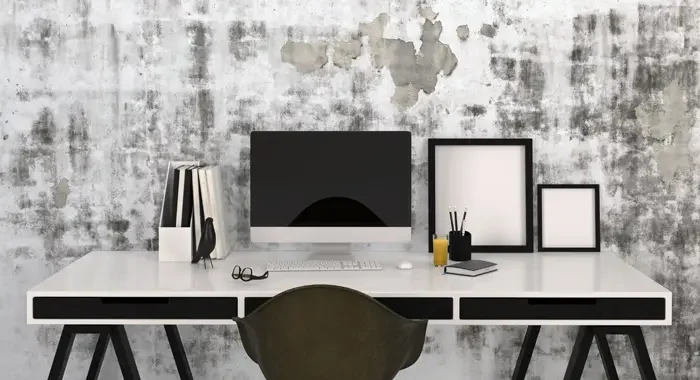 Designer-Schreibtisch mit All-in-One-Computer und vielen Utensilien